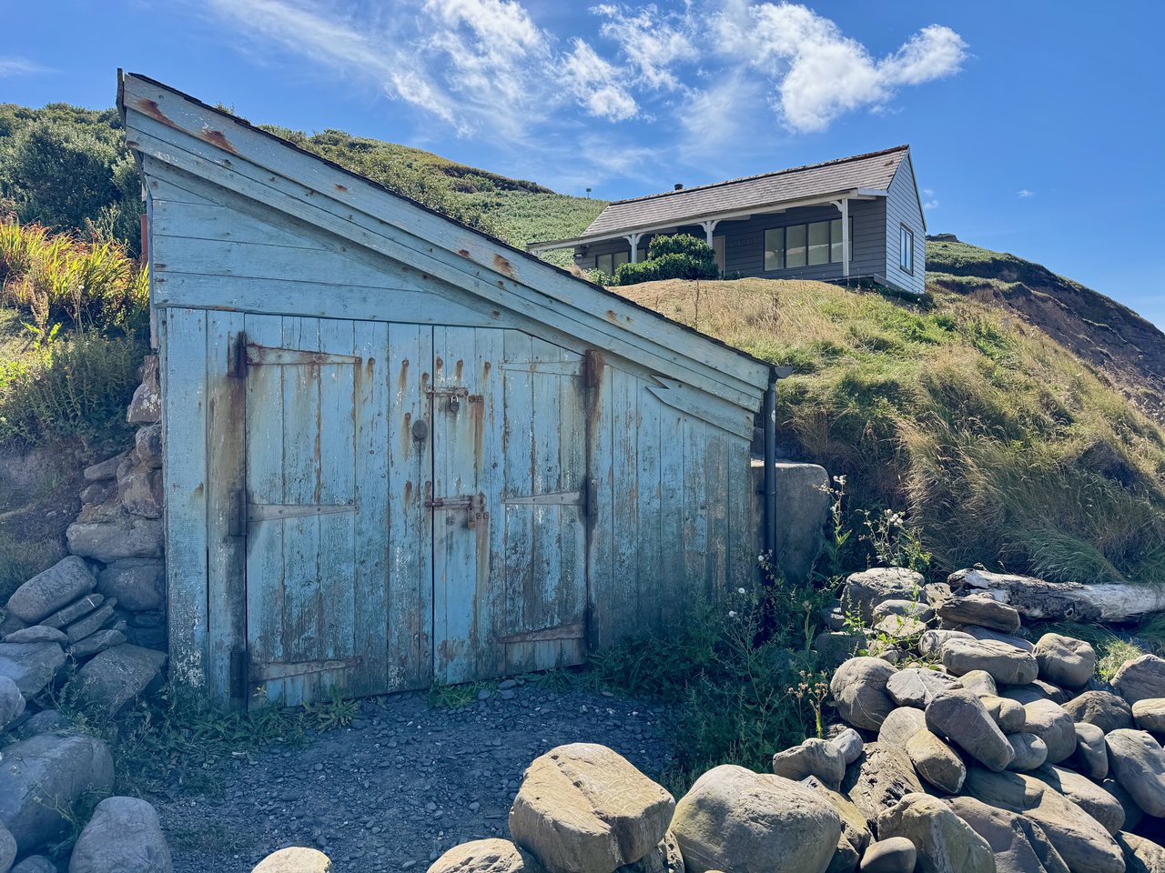 Blue Door. A weathered blue shed dug into the hillside.
