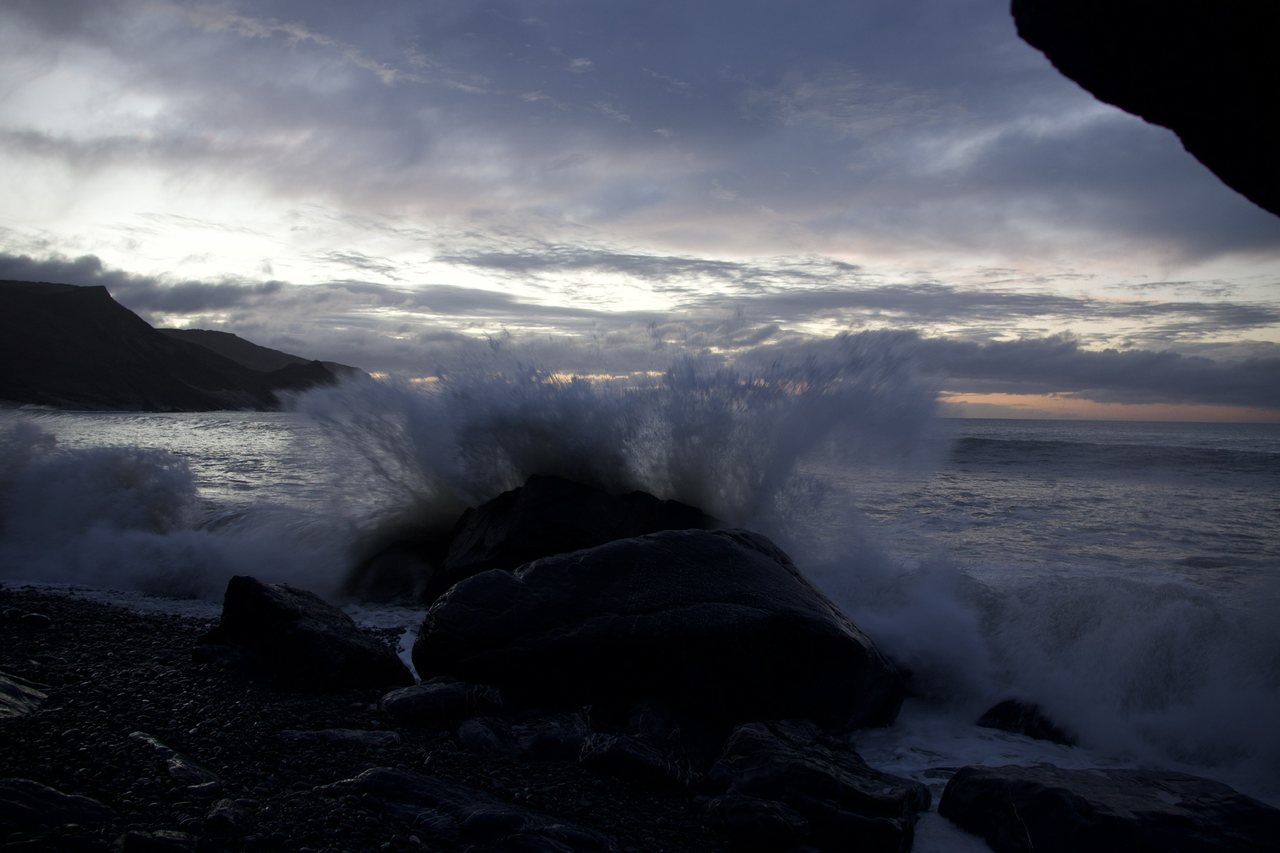 Breaker I. A wave breaking on the rocks, seen from under an overhang.